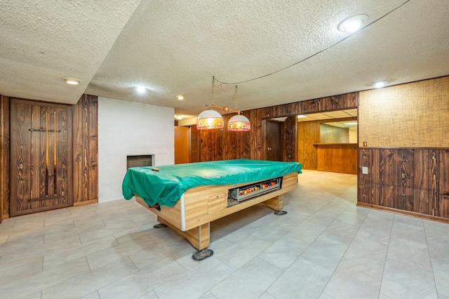 1005 32nd St, West Des Moines, IA 50266 - recreation room with wood walls, a textured ceiling, billiards, and a large fireplace