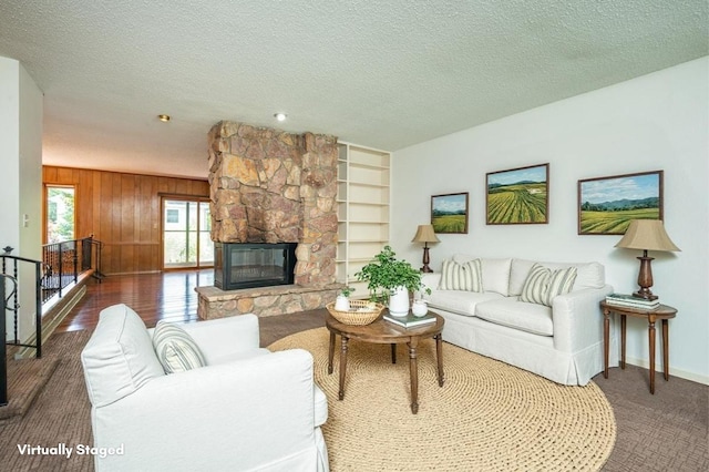1005 32nd St, West Des Moines, IA 50266 - living area featuring a textured ceiling, a fireplace, wood walls, and built in features