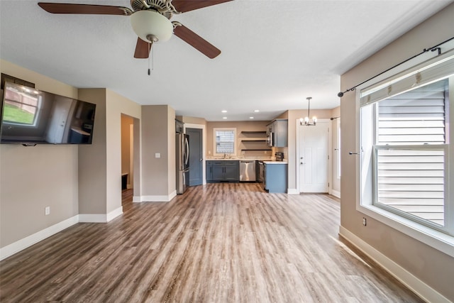 611 Court St, Adel, IA 50003 - unfurnished living room with wood finished floors, a chandelier, ceiling fan, healthy amount of natural light, and recessed lighting