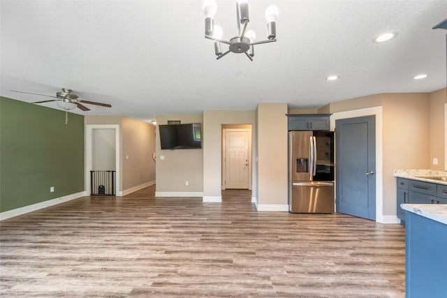 611 Court St, Adel, IA 50003 - unfurnished living room with light wood finished floors, ceiling fan, recessed lighting, and a chandelier