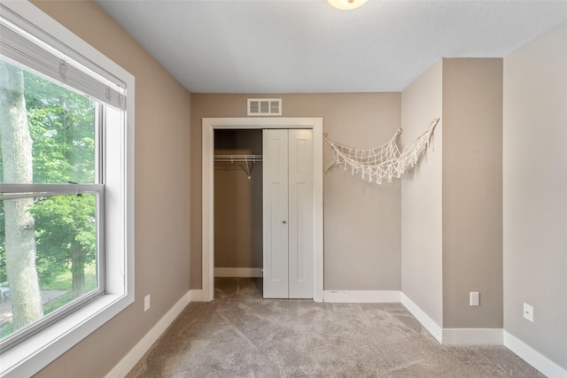 611 Court St, Adel, IA 50003 - unfurnished bedroom with multiple windows, carpet, and a closet
