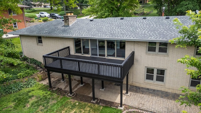 6730 NW Timberline Dr, Des Moines, IA 50313 - rear view of house with roof with shingles, a wooden deck, a chimney, and a patio