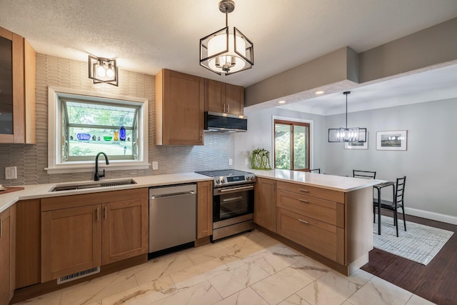 6730 NW Timberline Dr, Des Moines, IA 50313 - kitchen with appliances with stainless steel finishes, a peninsula, brown cabinets, and decorative backsplash