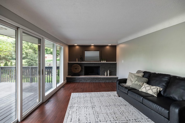 6730 NW Timberline Dr, Des Moines, IA 50313 - living room featuring wood finished floors, a brick fireplace, and a textured ceiling