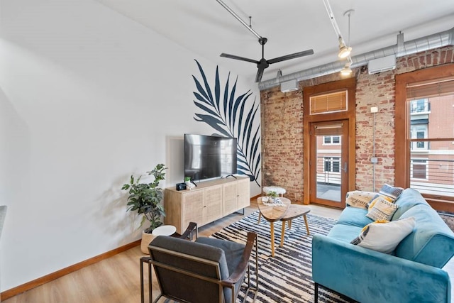 507 E Locust St Unit 308, Des Moines, IA 50309 - living area with wood finished floors, brick wall, and a ceiling fan
