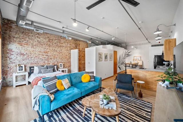 507 E Locust St Unit 308, Des Moines, IA 50309 - living area featuring brick wall, light wood finished floors, and ceiling fan