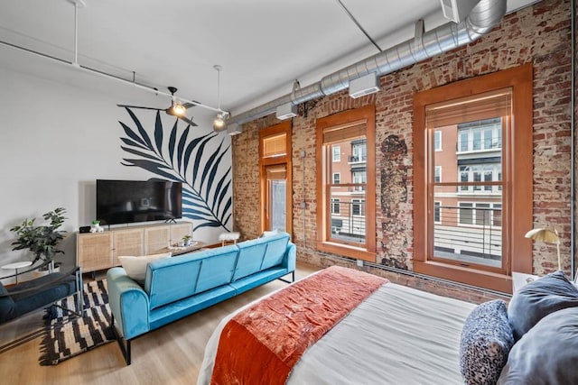 507 E Locust St Unit 308, Des Moines, IA 50309 - bedroom with brick wall and wood finished floors