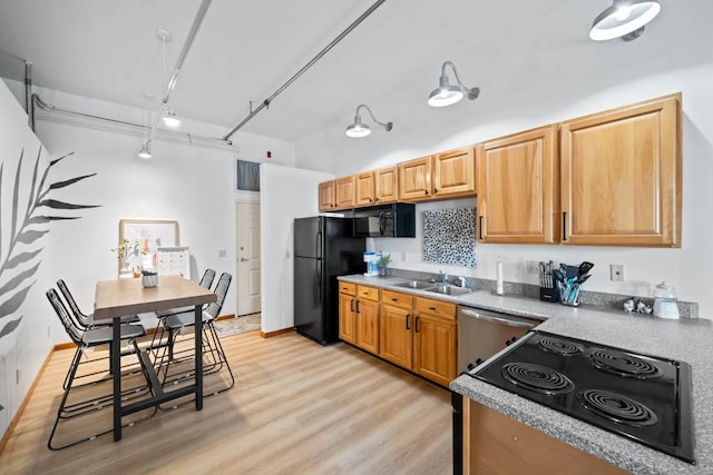507 E Locust St Unit 308, Des Moines, IA 50309 - kitchen featuring black appliances, light wood-style flooring, rail lighting, and light countertops