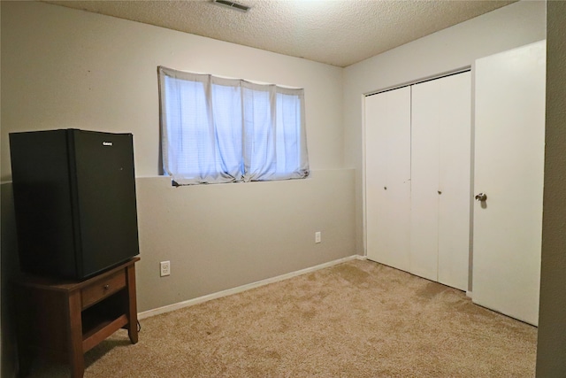 204 25th Ave SW, Altoona, IA 50009 - unfurnished bedroom featuring carpet floors, a textured ceiling, and a closet