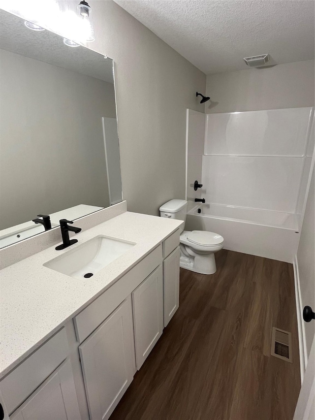 711 W N Ave, Norwalk, IA 50211 - bathroom with wood finished floors, vanity, a textured ceiling, and bathing tub / shower combination