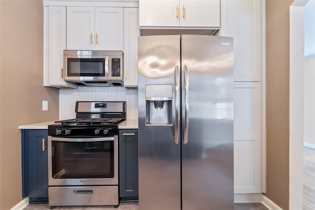 1918 55th St, Des Moines, IA 50310 - kitchen featuring appliances with stainless steel finishes, light countertops, tasteful backsplash, and white cabinets
