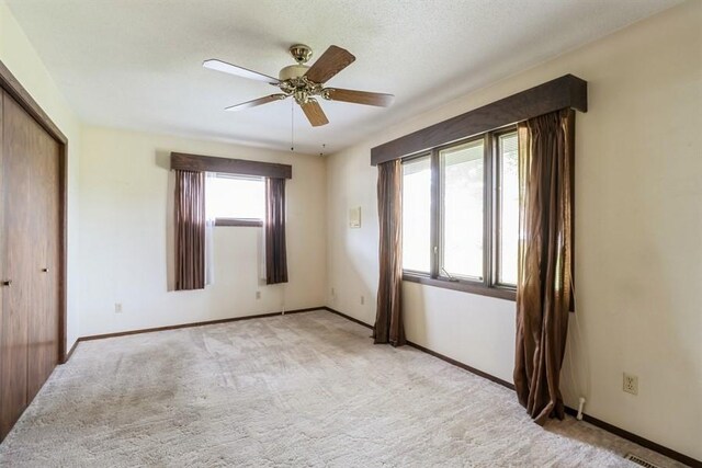 2907 Northwood Dr, Ames, IA 50010 - unfurnished bedroom featuring light carpet, a closet, and a ceiling fan