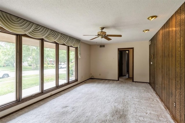 2907 Northwood Dr, Ames, IA 50010 - unfurnished room featuring wooden walls, light colored carpet, ceiling fan, and a textured ceiling