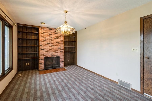 2907 Northwood Dr, Ames, IA 50010 - unfurnished living room featuring a chandelier, carpet floors, built in shelves, and a fireplace