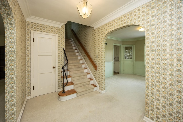 5800 Pleasant Dr, Des Moines, IA 50312 - staircase with arched walkways, wallpapered walls, ornamental molding, and carpet flooring