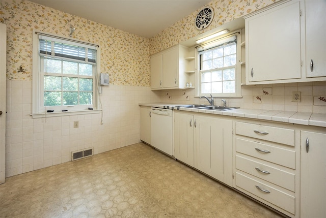 5800 Pleasant Dr, Des Moines, IA 50312 - kitchen featuring dishwasher, wallpapered walls, open shelves, a wainscoted wall, and tile walls