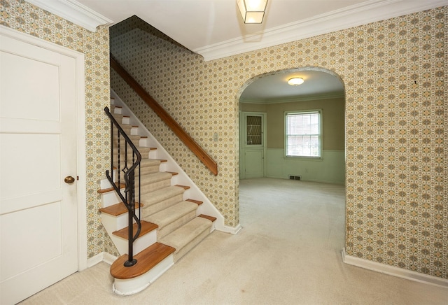 5800 Pleasant Dr, Des Moines, IA 50312 - staircase with arched walkways, ornamental molding, wallpapered walls, and carpet floors