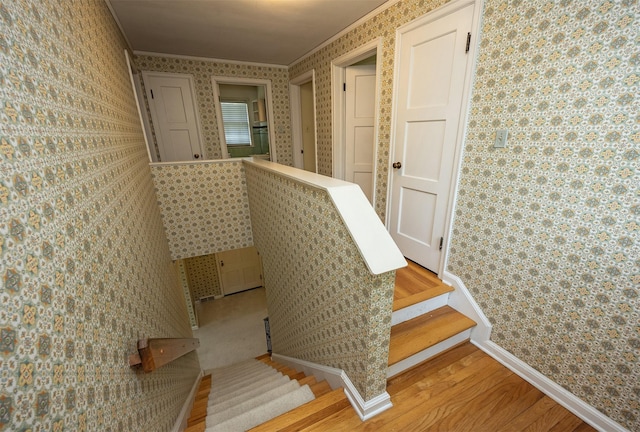 5800 Pleasant Dr, Des Moines, IA 50312 - staircase with wallpapered walls, ornamental molding, and wood finished floors