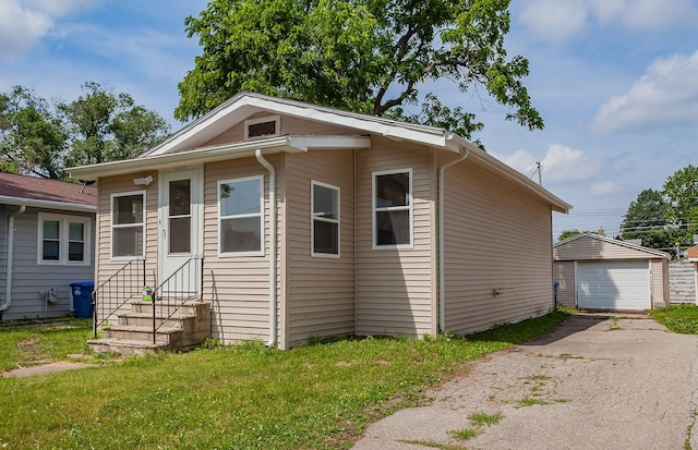 3308 Cambridge St, Des Moines, IA 50313 - view of front of property with entry steps, driveway, a detached garage, an outbuilding, and a front lawn