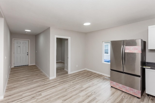3308 Cambridge St, Des Moines, IA 50313 - kitchen with freestanding refrigerator, light wood finished floors, white cabinets, recessed lighting, and dark countertops