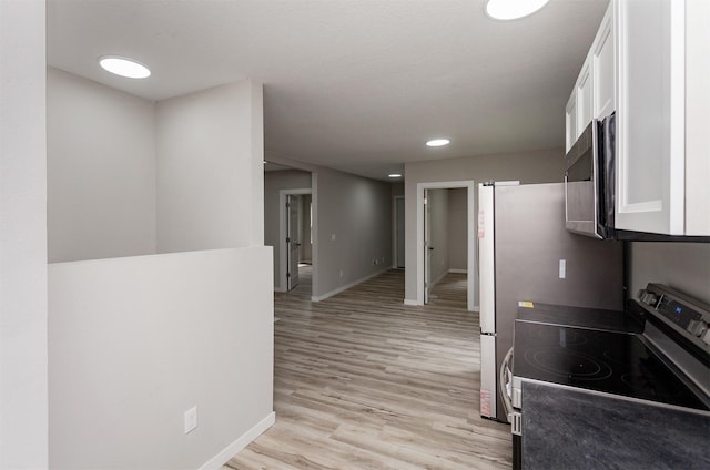 3308 Cambridge St, Des Moines, IA 50313 - kitchen with appliances with stainless steel finishes, white cabinetry, light wood-style floors, and recessed lighting