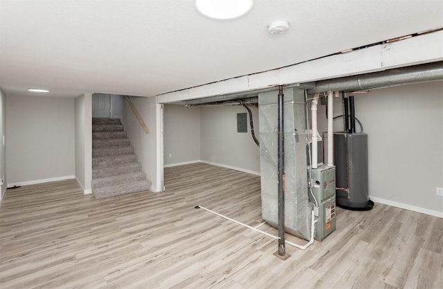 3308 Cambridge St, Des Moines, IA 50313 - finished below grade area featuring water heater, wood finished floors, heating unit, stairway, and electric panel