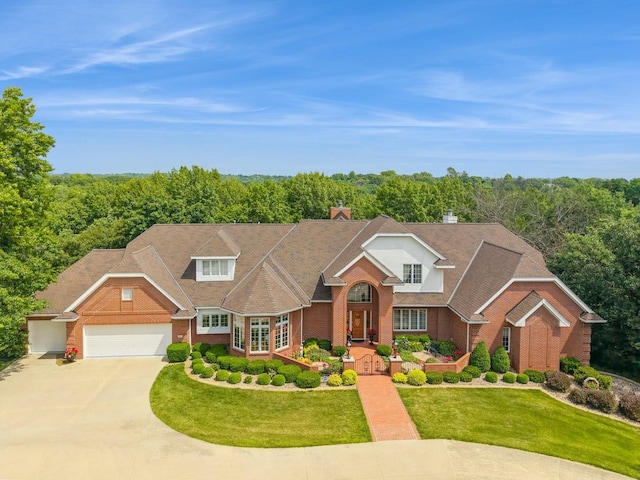 501 S 33rd St, West Des Moines, IA 50265 - traditional home with brick siding, driveway, a front lawn, an attached garage, and a forest view