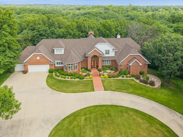 501 S 33rd St, West Des Moines, IA 50265 - traditional-style home with driveway, a forest view, a garage, a chimney, and a front yard