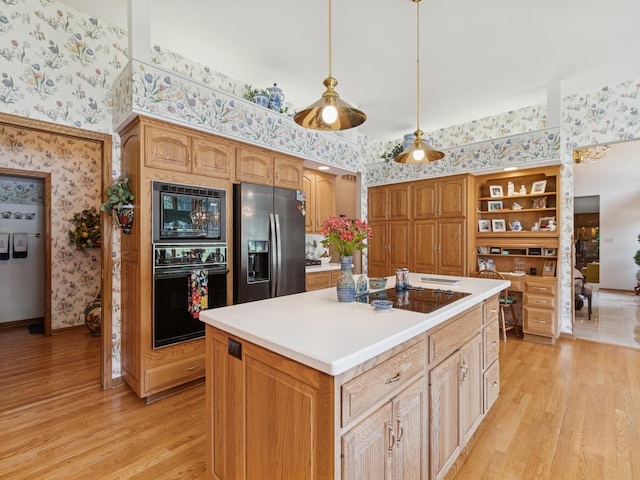 501 S 33rd St, West Des Moines, IA 50265 - kitchen with black appliances, wallpapered walls, light wood finished floors, a center island, and light countertops
