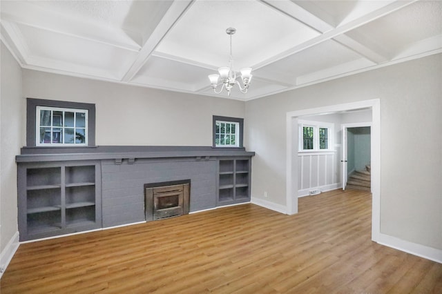 1418 33rd St, Des Moines, IA 50311 - unfurnished living room featuring coffered ceiling, wood finished floors, a chandelier, a brick fireplace, and beamed ceiling