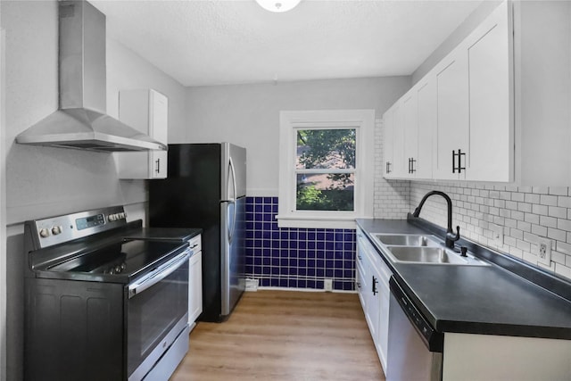 1418 33rd St, Des Moines, IA 50311 - kitchen featuring appliances with stainless steel finishes, wall chimney exhaust hood, dark countertops, white cabinets, and tile walls
