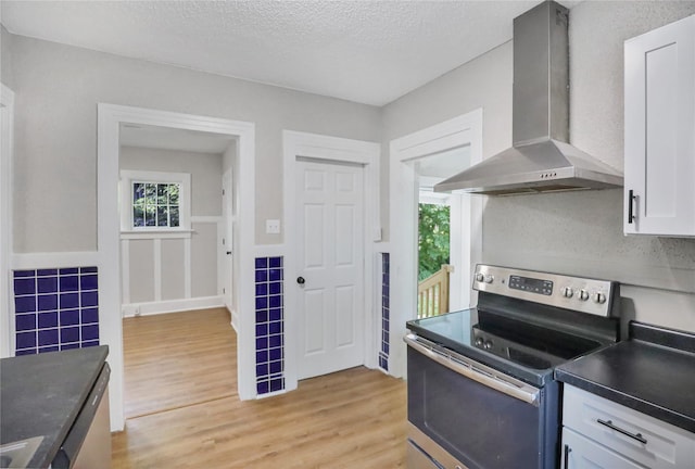 1418 33rd St, Des Moines, IA 50311 - kitchen featuring stainless steel electric range, island exhaust hood, plenty of natural light, white cabinets, and a textured ceiling