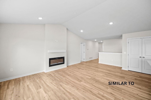 1927 20th Ave SE, Altoona, IA 50009 - unfurnished living room featuring light wood-style flooring, lofted ceiling, a glass covered fireplace, and recessed lighting