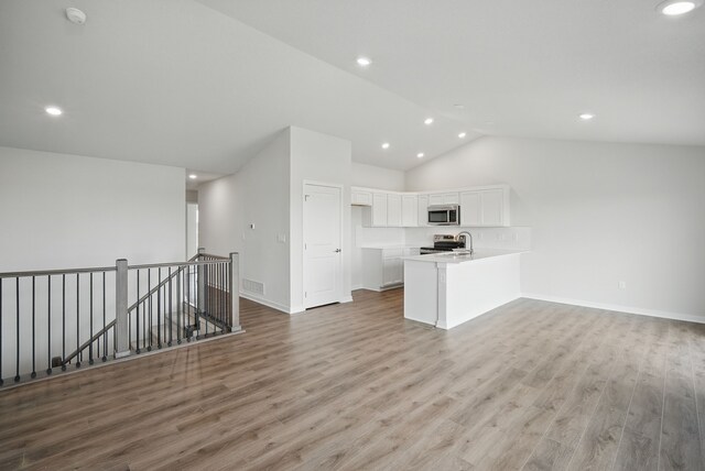 4270 Grover Woods Ln, Des Moines, IA 50317 - unfurnished living room featuring lofted ceiling, light wood-style floors, and recessed lighting