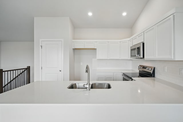 4270 Grover Woods Ln, Des Moines, IA 50317 - kitchen with stainless steel appliances, decorative backsplash, light countertops, white cabinets, and recessed lighting