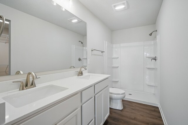 4270 Grover Woods Ln, Des Moines, IA 50317 - full bath with wood finished floors, a shower, double vanity, and a walk in closet