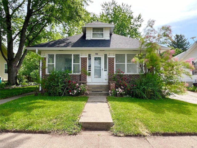 702 W 6th St S, Newton, IA 50208 - bungalow-style home featuring brick siding, a front lawn, and roof with shingles