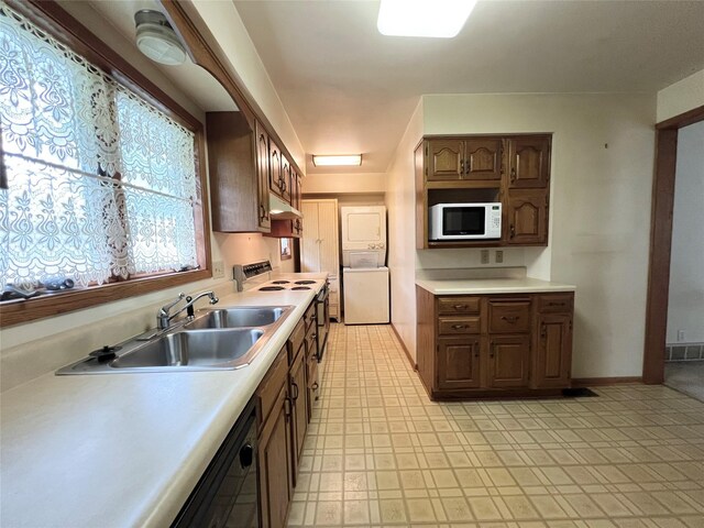 702 W 6th St S, Newton, IA 50208 - kitchen featuring white appliances, stacked washer / dryer, under cabinet range hood, and light countertops
