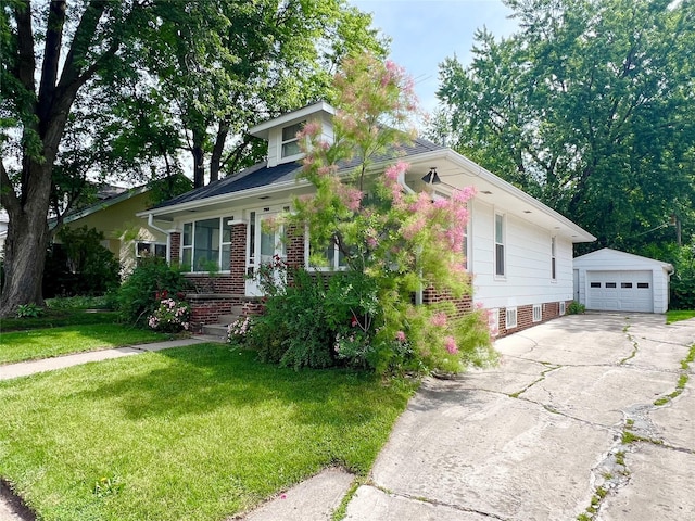 702 W 6th St S, Newton, IA 50208 - view of front of house featuring an outbuilding, a front lawn, a detached garage, brick siding, and driveway