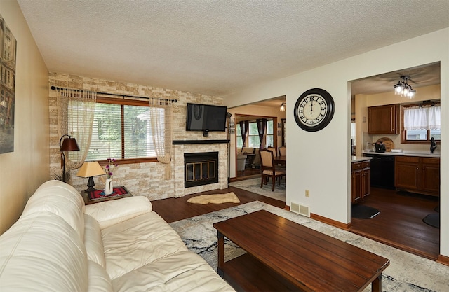 4718 71st St, Urbandale, IA 50322 - living area featuring a fireplace, a textured ceiling, and wood finished floors