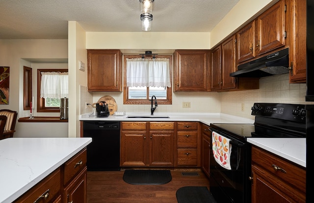 4718 71st St, Urbandale, IA 50322 - kitchen featuring black appliances, under cabinet range hood, dark wood-style floors, light countertops, and tasteful backsplash