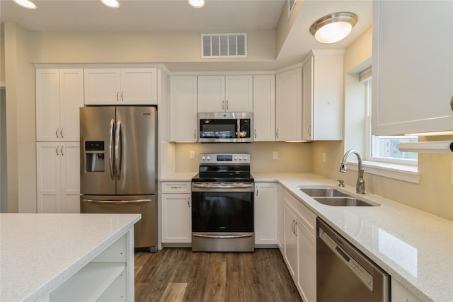 1250 SW Magazine Rd Unit 215, Ankeny, IA 50023 - kitchen with stainless steel appliances, white cabinets, dark wood-type flooring, light stone countertops, and recessed lighting