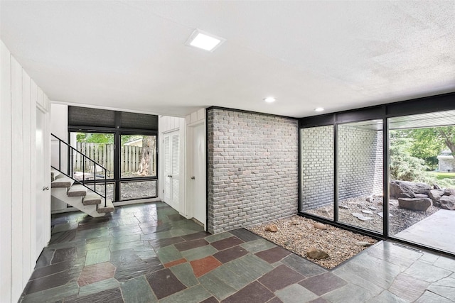 1808 80th St, Windsor Heights, IA 50324 - unfurnished room featuring stone tile floors, stairway, plenty of natural light, and recessed lighting