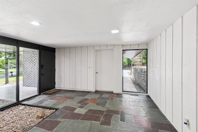 1808 80th St, Windsor Heights, IA 50324 - entrance foyer featuring a textured ceiling, stone finish floors, a decorative wall, and recessed lighting
