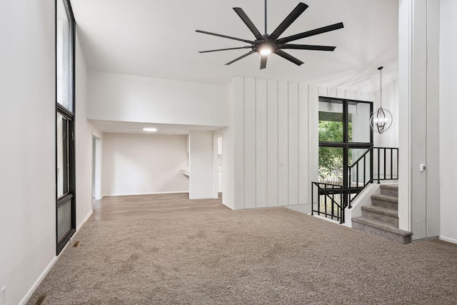 1808 80th St, Windsor Heights, IA 50324 - unfurnished room with carpet, a chandelier, a ceiling fan, and stairs