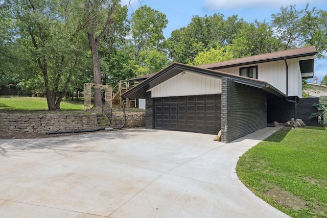 1808 80th St, Windsor Heights, IA 50324 - view of side of home featuring an attached garage, driveway, brick siding, and a yard