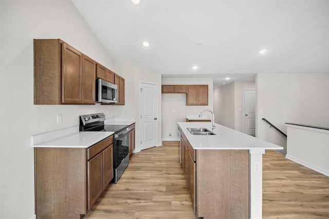 4400 Honey Bee Rdg, Des Moines, IA 50317 - kitchen with appliances with stainless steel finishes, light wood-style flooring, brown cabinets, recessed lighting, and an island with sink