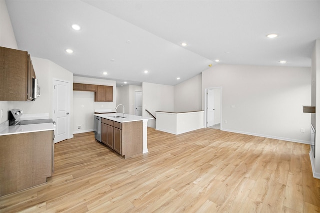 4400 Honey Bee Rdg, Des Moines, IA 50317 - kitchen featuring light wood finished floors, appliances with stainless steel finishes, lofted ceiling, a kitchen island with sink, and open floor plan