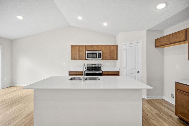 4400 Honey Bee Rdg, Des Moines, IA 50317 - kitchen with appliances with stainless steel finishes, light countertops, light wood finished floors, brown cabinetry, and lofted ceiling