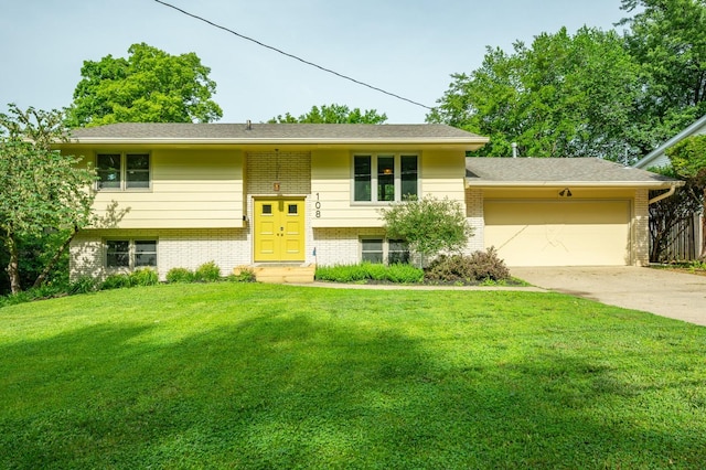 108 56th St, Des Moines, IA 50312 - raised ranch featuring brick siding, a garage, a front lawn, and concrete driveway
